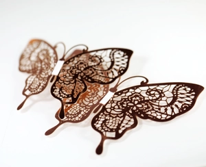 Close-up of rose gold hollow butterfly wall stickers with intricate laser-cut patterns