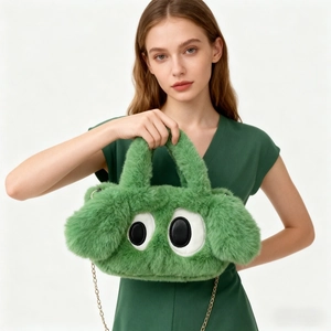 Sac à main en peluche verte avec de grands yeux et une bandoulière chaîne dorée