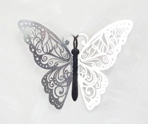 Close-up of 3D hollow butterfly wall sticker with silver metallic finish and scroll pattern