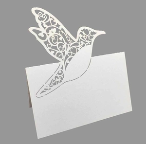 Macro detail of laser-cut hummingbird place card with intricate floral hollow patterns