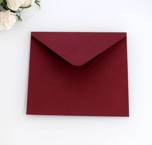 Macro shot of 150g pearlescent dark burgundy square envelope with elegant V-flap texture