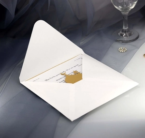 Detail of elegant white wedding invitation with gold heart seal and script text