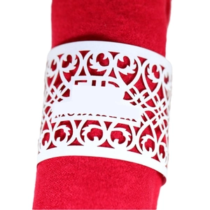 White laser-cut Eid Mubarak napkin ring with intricate pattern on a red cloth napkin