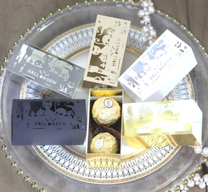 Detail of laser-cut Halloween gift boxes with pumpkin and castle motifs for chocolate