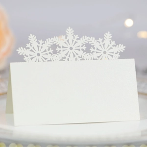 Elegant white laser-cut snowflake place cards with pearlescent finish for wedding and party