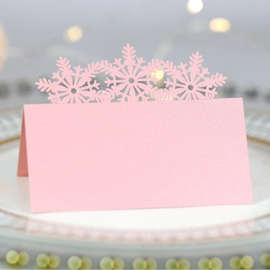 Pink laser-cut snowflake place card for Christmas and weddings on elegant dinner plate