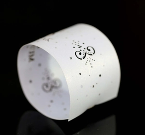 Macro shot of laser-cut white pearlescent napkin ring with delicate star patterns