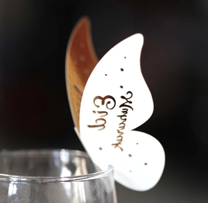 Close-up of laser-cut butterfly cup card with Eid Mubarak text on glass rim