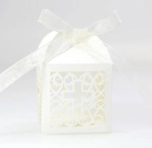 Détail de boîte de mariage découpée au laser blanche avec motifs de croix et ruban