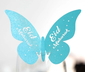 Macro detail of light blue butterfly glass card with Eid Mubarak print and glitter finish