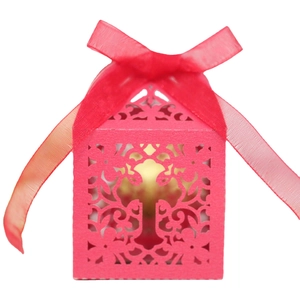 Magenta laser cut candy box featuring a cross design and elegant organza ribbon tie
