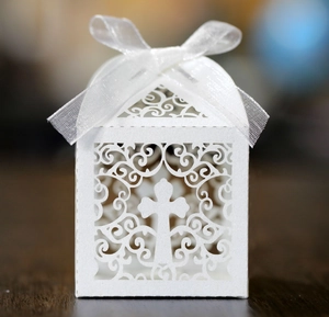 Détail d'une boîte à dragées blanche découpée au laser avec croix et ruban satin