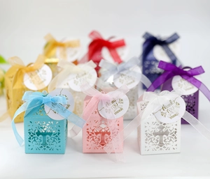 Detail of laser-cut wedding favor boxes with ribbons and Thank You tags in various colors