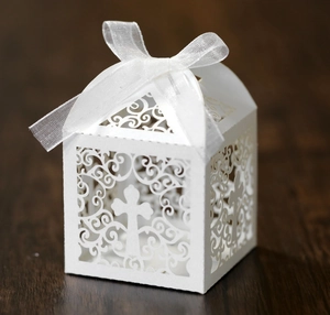Détail de la boîte à bonbons ajourée au laser avec motif de croix et ruban blanc