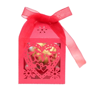 Pink laser-cut love heart wedding favor box with ribbon and ornate floral patterns