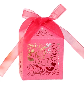 Pink laser-cut rose gift box for wedding favors with matching ribbon on white background