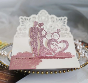 Detail of laser-cut 3D wedding invitation with Mr & Mrs text and rose gold glitter