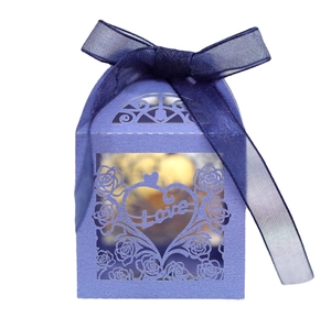 Boîte à bonbons rose évidée violette avec ruban d'organza bleu et chocolats dorés