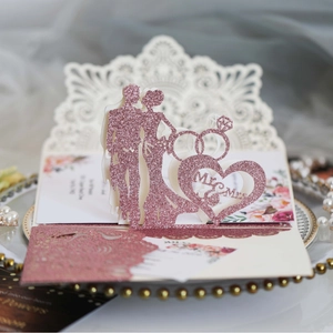 Pink glitter laser-cut 3D wedding invitation card featuring bride and groom silhouette