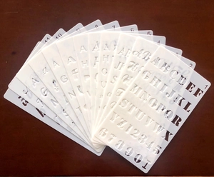 Close-up of 12 transparent PET alphabet and number stencils for DIY painting