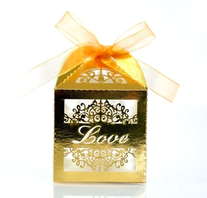 Golden laser cut Love wedding favor box with an orange ribbon bow for sweets