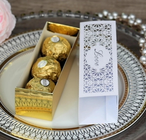 Elegant laser-cut pink wedding favor box with gold base and Love script pattern