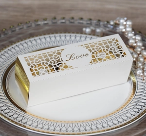 Lasercut weiße Hochzeits-Geschenkbox mit Love-Schriftzug und goldenen Pralinen