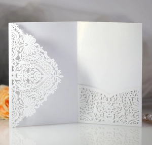 Détail du motif floral découpé au laser sur une élégante invitation en papier nacré blanc