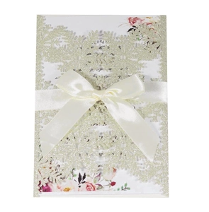 Laser cut champagne gold glitter wedding invitation with snowflake pattern and ribbon