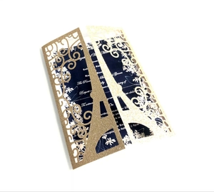 Macro detail of laser-cut Eiffel Tower wedding invitation with gold glitter texture