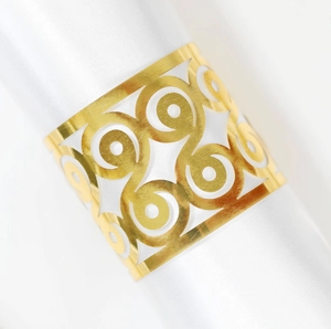 Eleganter goldener Serviettenring mit geometrischem Muster auf weißem Satinstoff