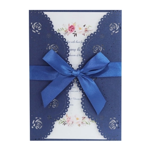 Elegant laser cut rose wedding invitation card in navy blue with a satin ribbon bow