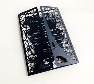 Detail of laser-cut black Eiffel Tower and floral pattern on elegant invitation card