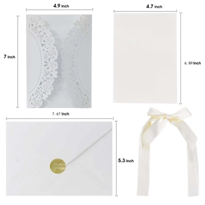 Laser cut floral wedding invitation set with white envelopes and gold ribbon