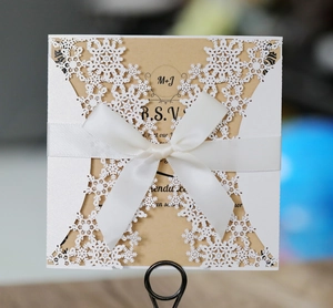 Invito a nozze elegante con fiocco e fiocco di neve tagliato al laser su kraft