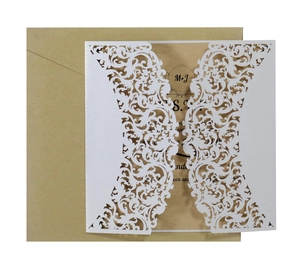 Elegant white laser-cut wedding invitation set with lace patterns and kraft envelope