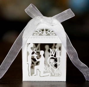 Elegant white laser-cut wedding favor box with romantic proposal silhouette and ribbon
