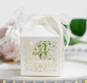 Elegante elfenbeinfarbene Laser-Cut-Kreuz-Zuckerdose mit weißem Organzaband für Hochzeiten