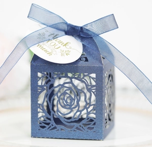 Navy blue glitter favor box with laser-cut rose patterns and blue ribbon bow