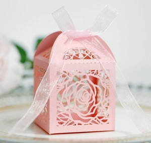Pink hollow rose wedding candy box with delicate laser-cut floral patterns and ribbon