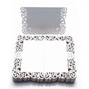White laser-cut lace wedding place cards with elegant scroll patterns for guest seating