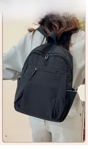 Detail of black nylon backpack with multi-layer zipper pockets and side storage for commuting