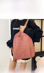Close-up of pink water-resistant nylon backpack with zipper detail and side pocket
