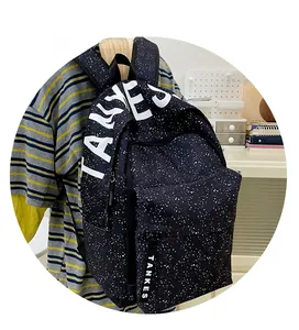 Detail view of the side profile on a black backpack with white star patterns and TANKS logo
