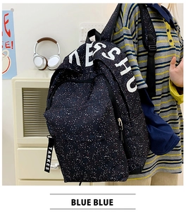Detail view of black backpack with white star speckle print and NESHU lettering detail