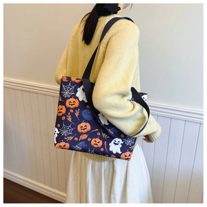 Dettaglio della grande borsa tote blu navy con stampa Halloween indossata dal modello