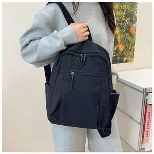 Detail view of water-resistant nylon backpack with side pockets and smooth zipper design