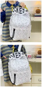 Detail of white splatter-pattern backpack featuring black and red spots and TANKES logo strap