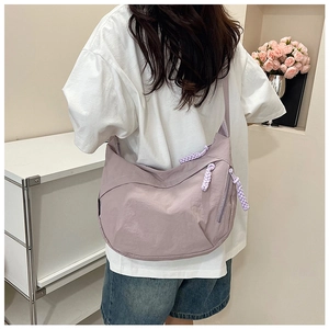 Détail du sac demi-lune en nylon mauve avec tirette de fermeture éclair tressée