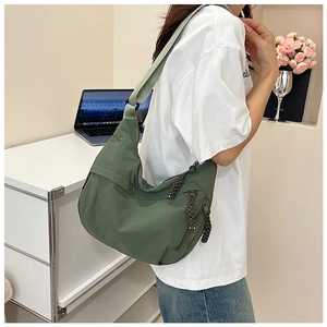 Détail du sac dumpling en nylon vert forêt avec bandoulière réglable et tirette tressée
